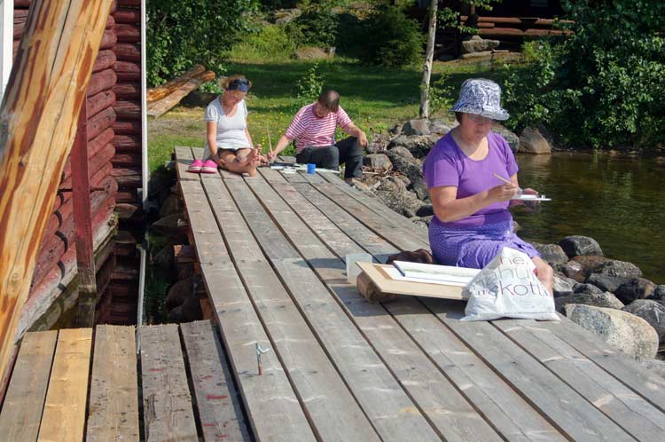 Stretching the watercolor paper with the use of tape after wetting it. The Puukonsaari art workshop.